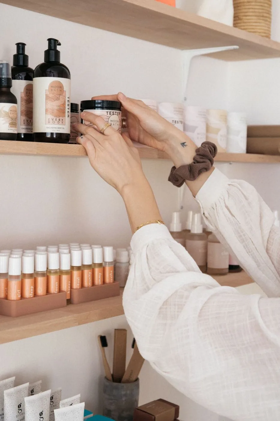 Shop owner arranging a product display on a retail shelf