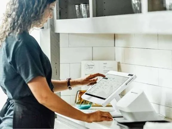 Cafe employee ringing up an order on a Clover Station Solo